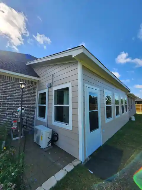 Finished sunroom addition with lap siding and a row of windows