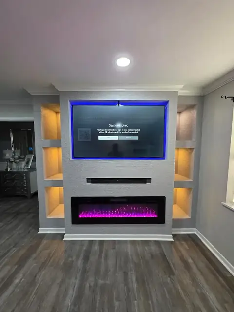 Built-in media wall with a linear fireplace and lit shelving niches