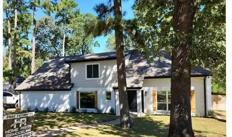 The same house painted white with a black roof and cedar shutters